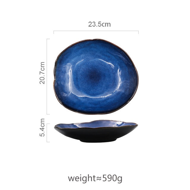 Large Atlas dinner plate, deep blue ceramic with irregular shape and dark rim, 23.5cm wide.