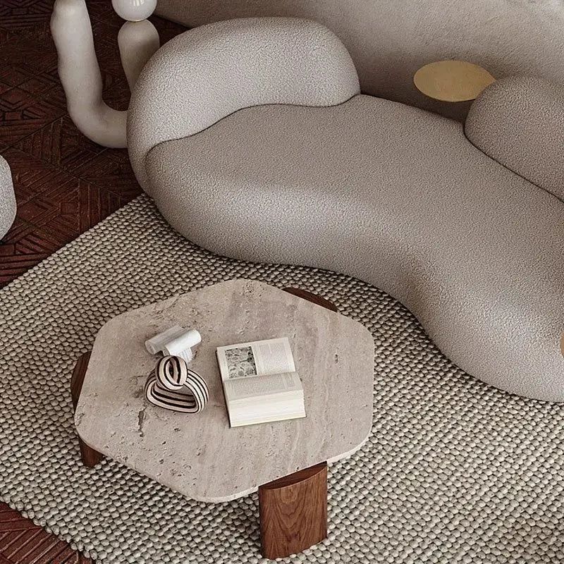 Borra Coffee Table: Hexagonal travertine top with dark wood base, on a textured rug next to a curved sofa.