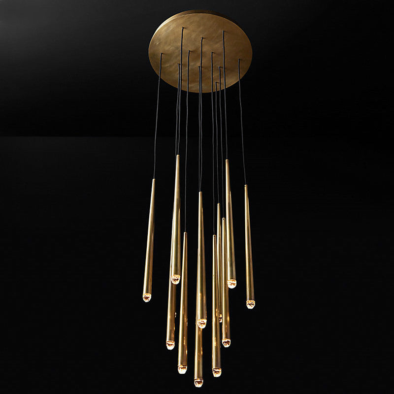 Evora pendant chandelier with multiple brass tubes and clear glass tips hanging from a round brass ceiling plate.