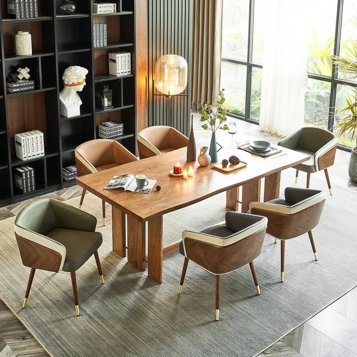 Modenal dining chair in green and brown leather with wood and gold legs, around a wooden dining table.