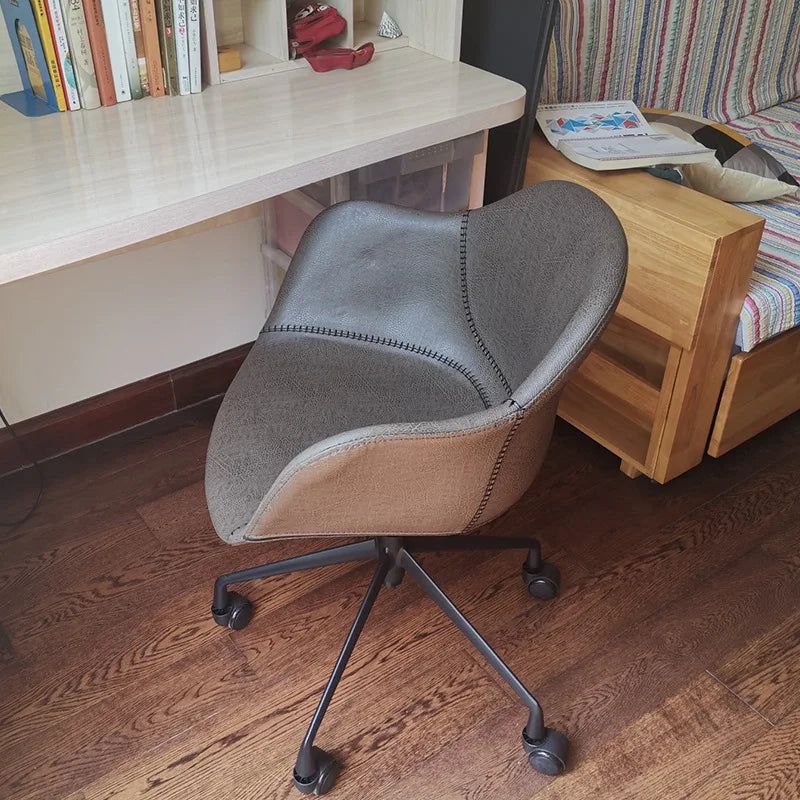 Prescott Office Chair: Brown faux leather office chair with stitched details and black caster wheels.
