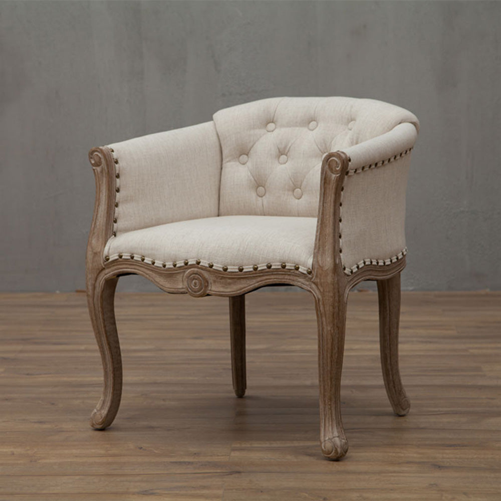 Willem Accent Chair: Beige upholstered accent chair with tufted back, distressed wood frame, and nailhead trim.