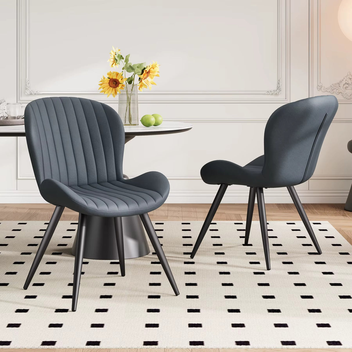 Lorca dining chair in dark gray fabric with vertical channel tufting and black tapered legs.