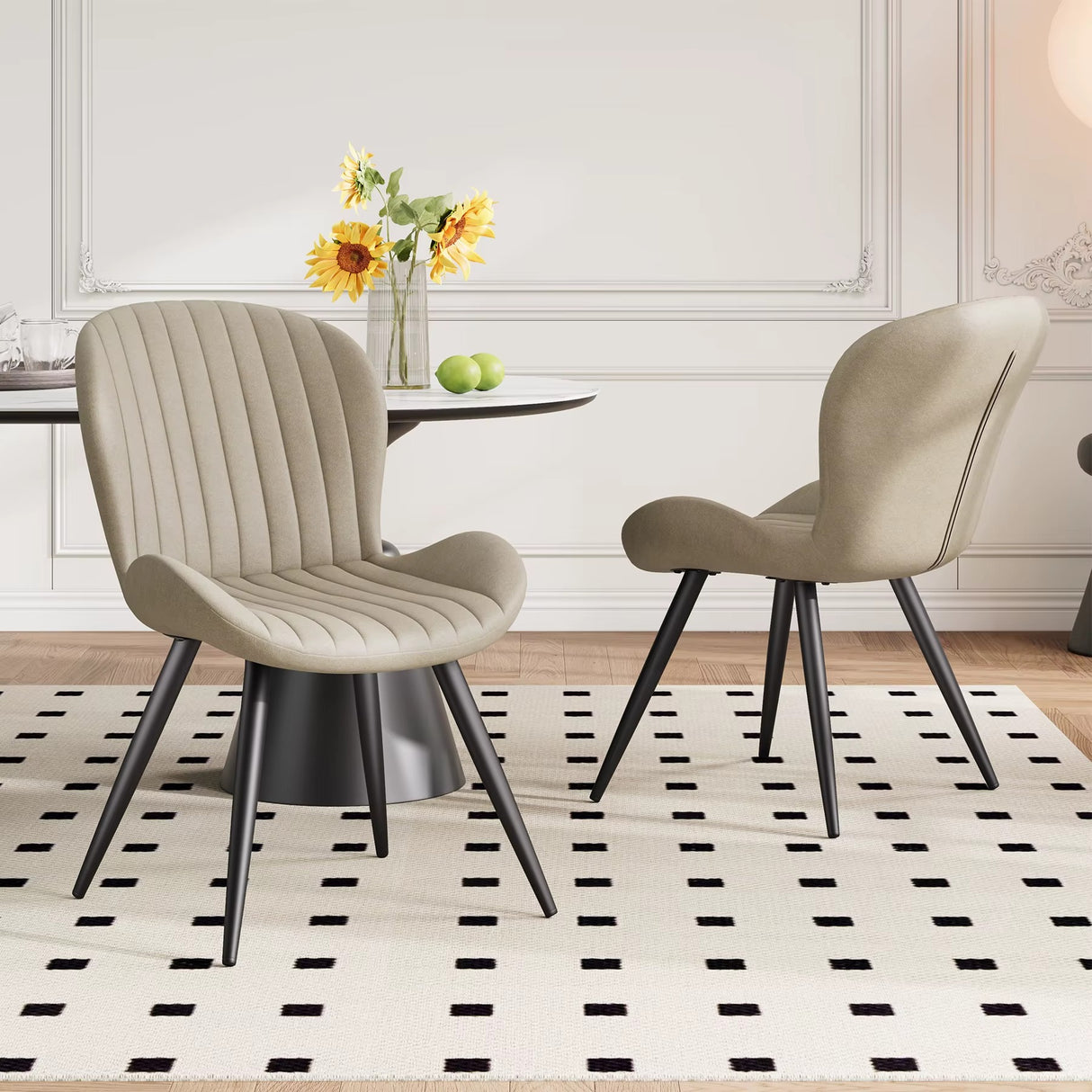 Lorca Dining Chair in beige fabric with vertical channel tufting and black tapered legs, shown in a dining room.