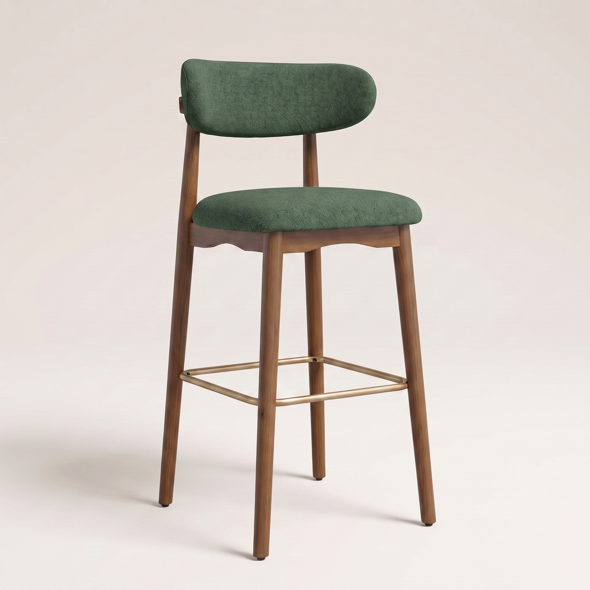 A modern bar stool with a green upholstered seat and curved backrest, supported by a medium brown wooden frame with a gold metal footrest, set against a plain light beige background.