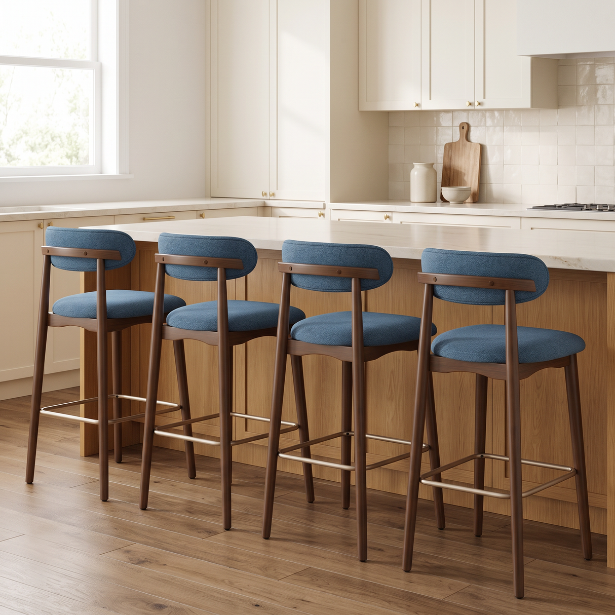 Four mid-century modern bar stools with blue upholstered seats and backs on wooden legs, arranged around a kitchen island in a bright, contemporary kitchen.