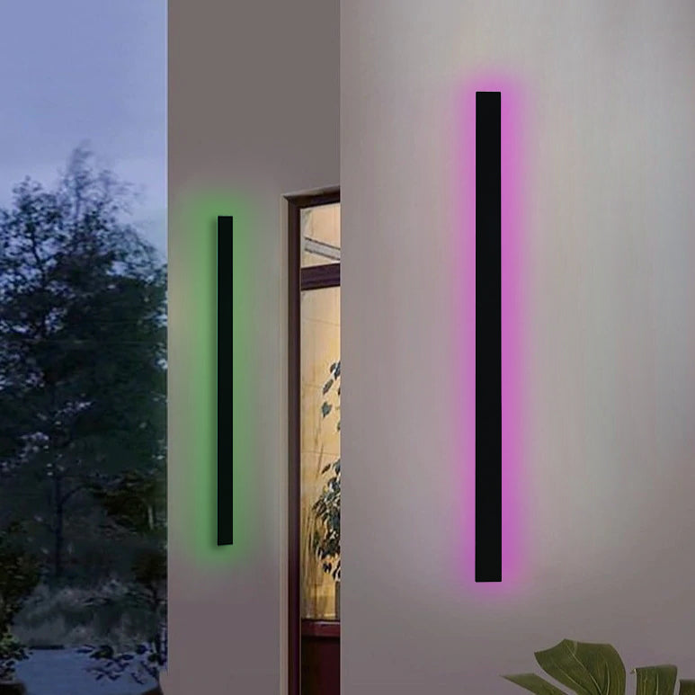 Parc Sconce outdoor wall light, black linear design, emitting green and pink RGB light on a white wall.