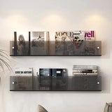 Avenue wall-mounted magazine shelf in smoke acrylic, holding magazines on a white wall.