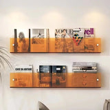 Orange acrylic wall-mounted magazine shelf, 30cm, holding magazines on a white wall.