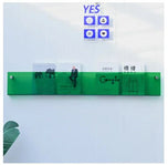 Green Avenue Wall-Mounted Magazine Shelf, 30cm, holding four magazines on a white wall.