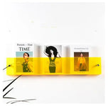 Yellow Avenue wall-mounted magazine shelf, 30cm, holding three magazines.