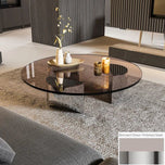 Bassano coffee table with round bronzed glass top and polished steel base on a gray rug.