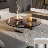 Bassano coffee table with round bronzed glass top and polished steel base on a gray rug.