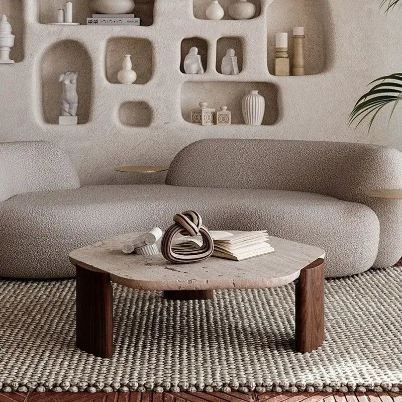 Borra coffee table with a light stone top and dark wood legs in a living room setting.