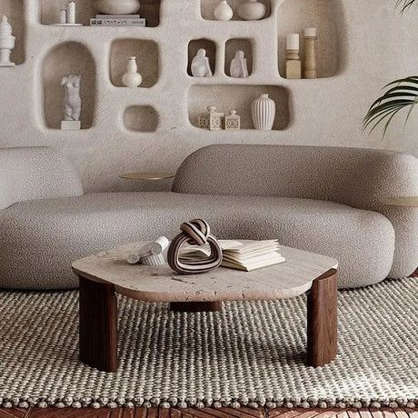 Borra coffee table with a light stone top and dark wood legs in a living room setting.