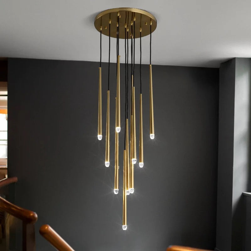 Evora gold pendant chandelier with multiple long, thin brass tubes and illuminated tips hanging from a round ceiling plate.