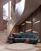 Evora pendant chandelier with multiple gold-toned tubes and small lights, hanging over a curved blue velvet sofa.
