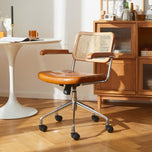 Lox office chair with light brown leather seat, cane back, wood arms, and chrome rolling base.