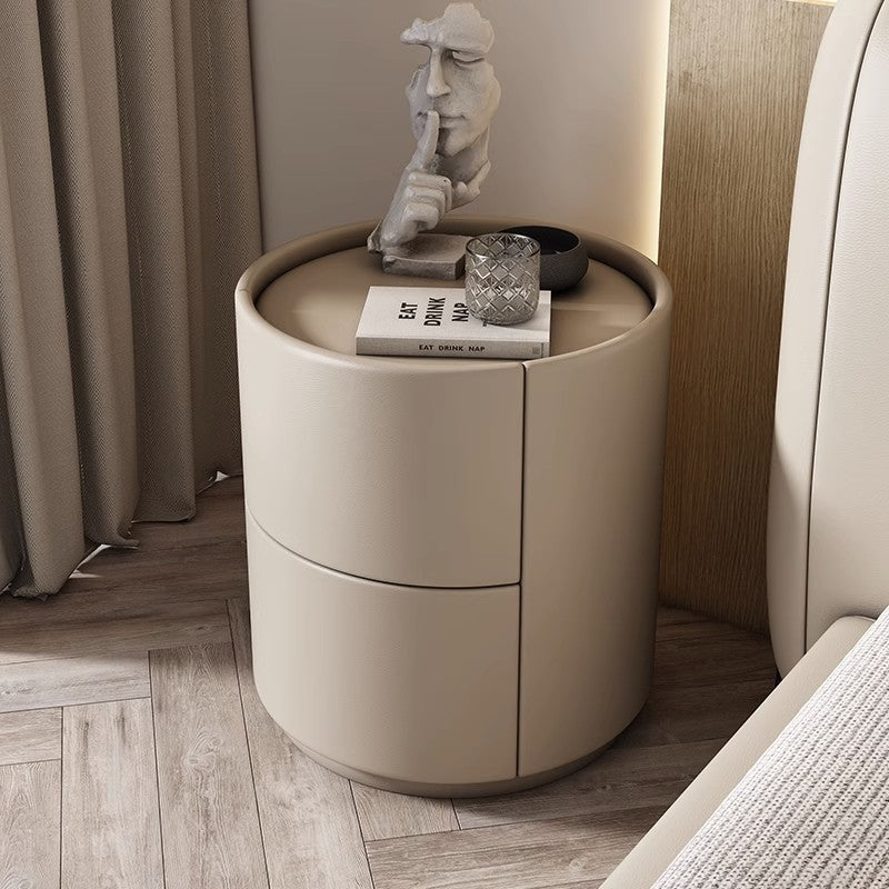Mira Bedside Table: Round beige leather nightstand with two curved drawers and a flat top surface.