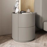 Mira Bedside Table, light grey, round, with two drawers and a flat top, on a light wood floor.