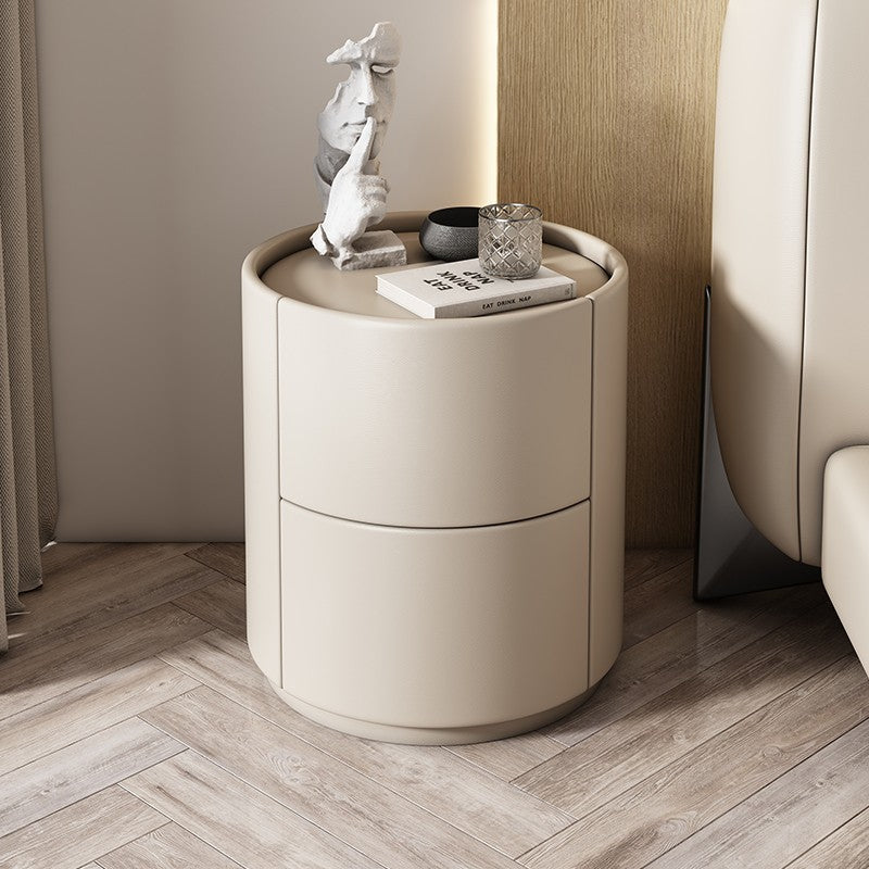 Mira Bedside Table: Round beige leather nightstand with two drawers and a recessed top.