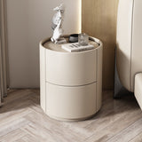 Mira Bedside Table: Round beige leather nightstand with two drawers and a recessed top.