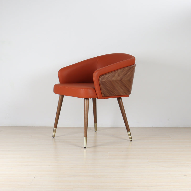 Modenal dining chair in burnt orange solid upholstery with walnut wood back and legs, brass leg caps.