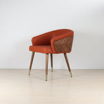 Modenal dining chair in burnt orange solid upholstery with walnut wood back and legs, brass leg caps.