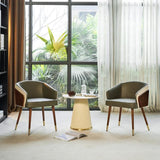 Two Modenal dining chairs with olive green upholstery, wood accents, and gold-capped legs flank a round white table.