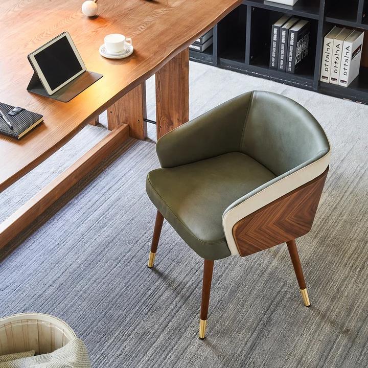 Modenal dining chair with olive green leather, light cream accents, and dark wood chevron back.