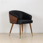 Modenal dining chair with black solid upholstery, dark wood back accent, and tapered wood legs with brass caps.