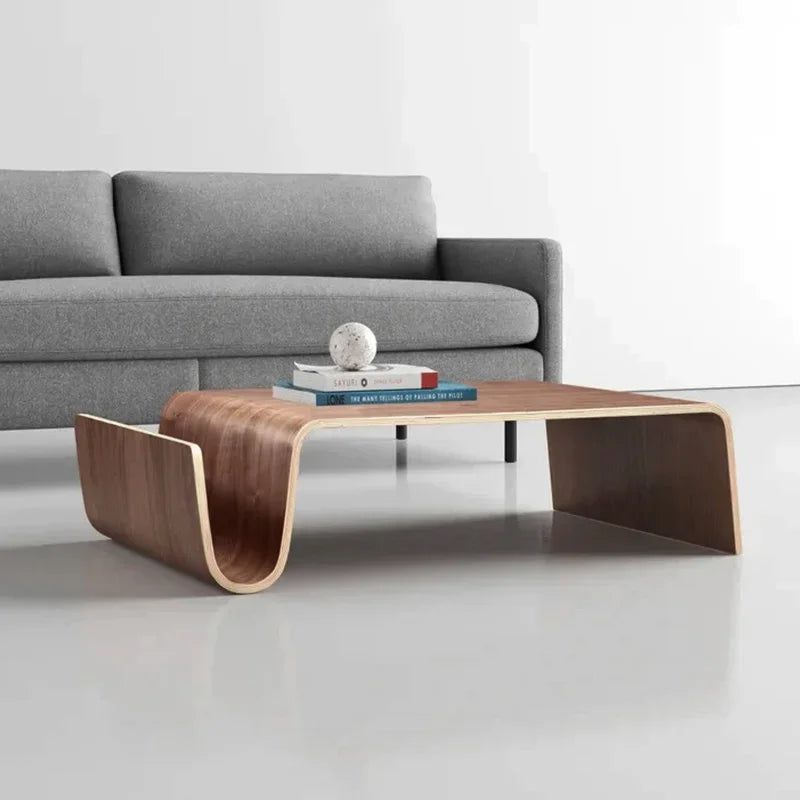 Montecito Coffee Table: Mid-century modern bentwood coffee table with a walnut finish, next to a gray sofa.
