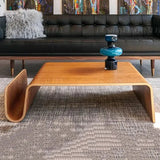 Montecito Coffee Table: Mid-century modern bentwood coffee table with a light brown finish and curved magazine holder.
