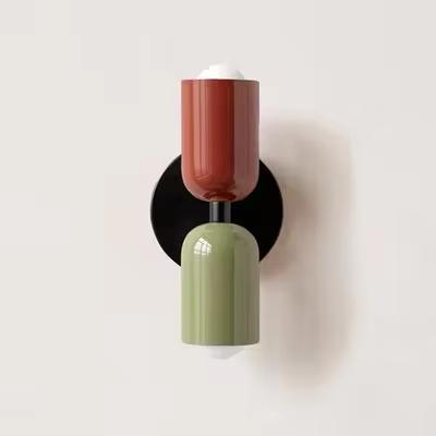 Mura Wall Light, a modern wall sconce with stacked terracotta and sage green cylindrical shades on a black base.