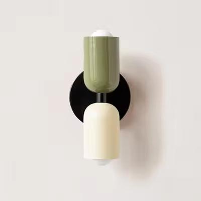 Mura Wall Light, a modern wall sconce with stacked olive green and cream cylindrical shades on a black base.