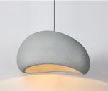 Nara pendant light, 12-inch light gray, with a textured, organic-shaped shade and warm glow.