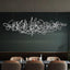Parcaso Chandelier, 80cm chrome abstract linear chandelier with warm white light over a dining table.
