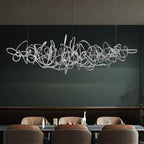 Parcaso Chandelier, 80cm chrome abstract linear chandelier with warm white light over a dining table.