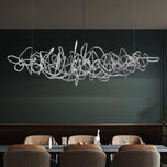 Parcaso Chandelier, 80cm chrome abstract linear chandelier with warm white light over a dining table.