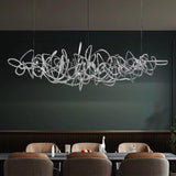 Parcaso Chandelier, 80cm chrome abstract linear chandelier with warm white light over a dining table.
