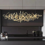 Parcaso Chandelier, 80cm gold abstract linear chandelier with warm white light over a black kitchen island.