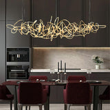 Parcaso Chandelier: Modern gold metal abstract chandelier over a dining table.