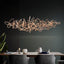 Parcaso Chandelier, 80cm rose gold abstract linear chandelier with warm white light over a dining table.