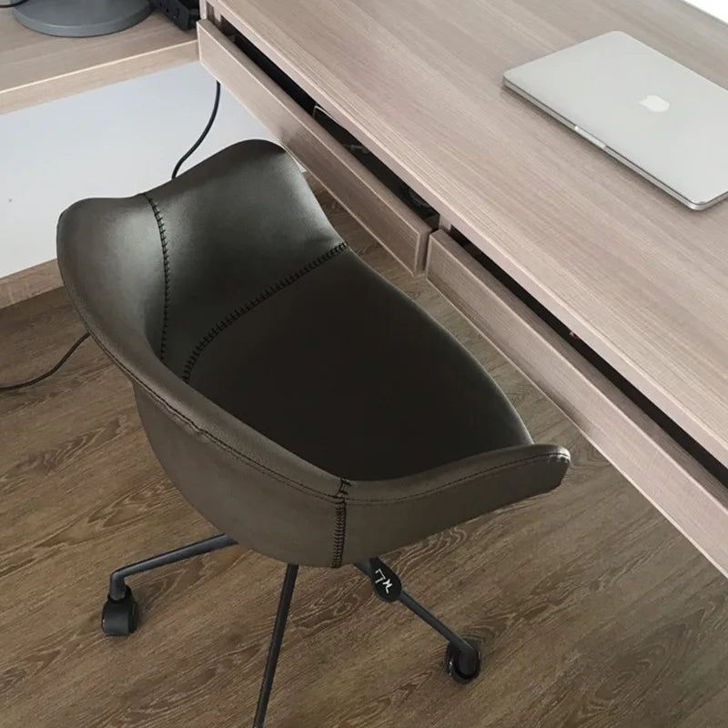 Prescott Office Chair: Dark brown leatherette office chair with black metal base and casters, beside a light wood desk.
