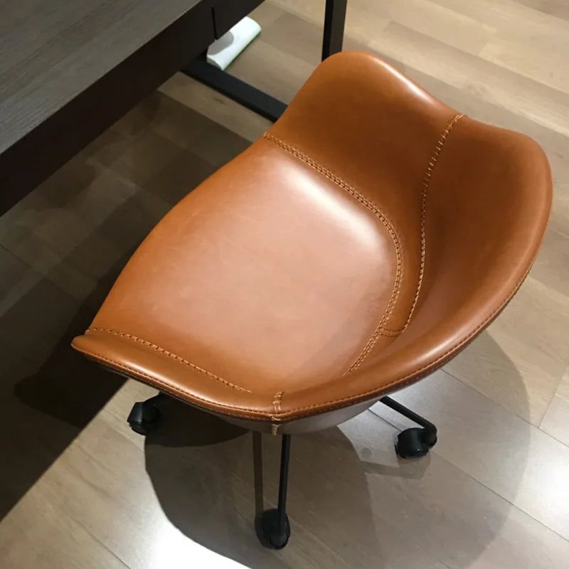 Prescott Office Chair: Tan leather office chair with visible stitching and black caster wheels on a wood floor.