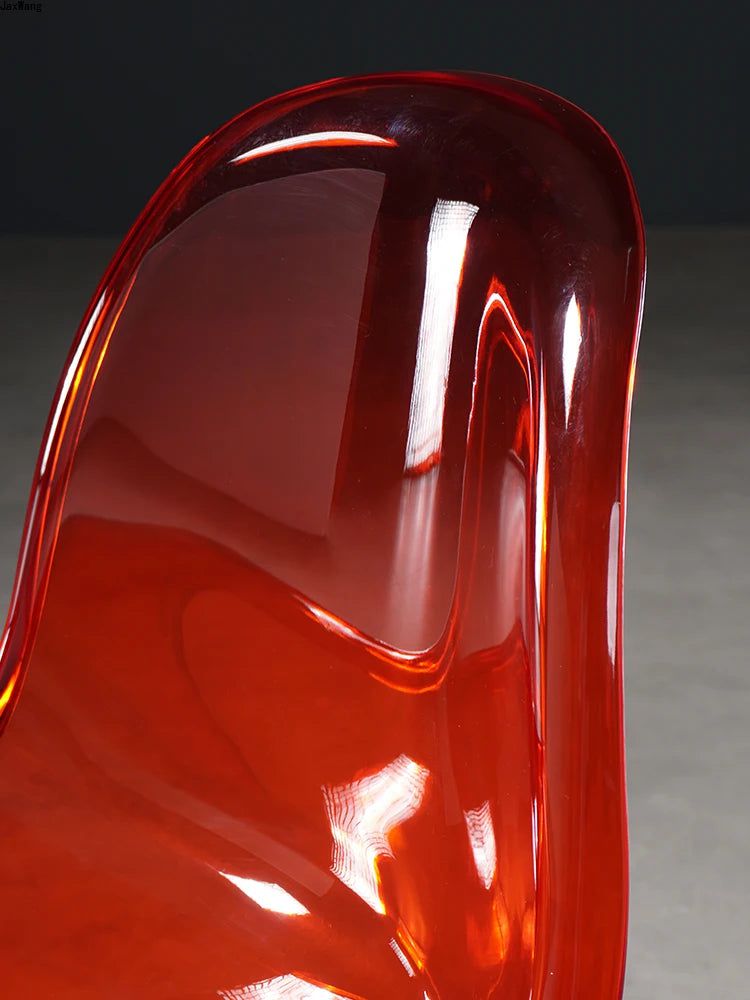 Sora Dining Chair, close-up of a translucent red acrylic chair with a curved back and seat.