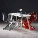 Sora Dining Chair: Clear, smoke, amber, and red acrylic chairs with curved backs around a white dining table.