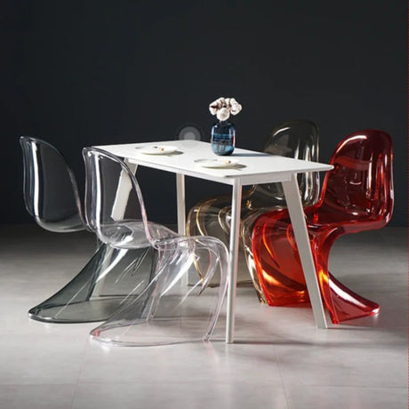 Sora Dining Chair: Clear, smoke, amber, and red acrylic chairs with curved backs around a white dining table.