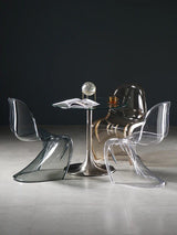 Sora Dining Chair: Clear and smoke gray acrylic dining chairs with curved backs and seats around a glass-top table.
