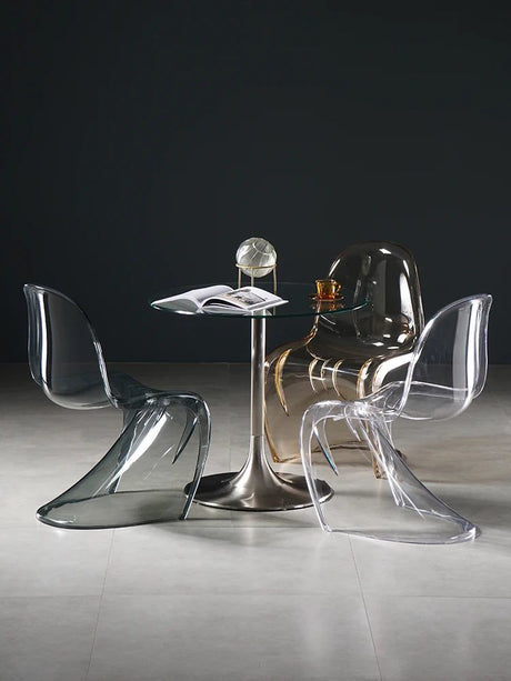 Sora Dining Chair: Clear and smoke gray acrylic dining chairs with curved backs and seats around a glass-top table.